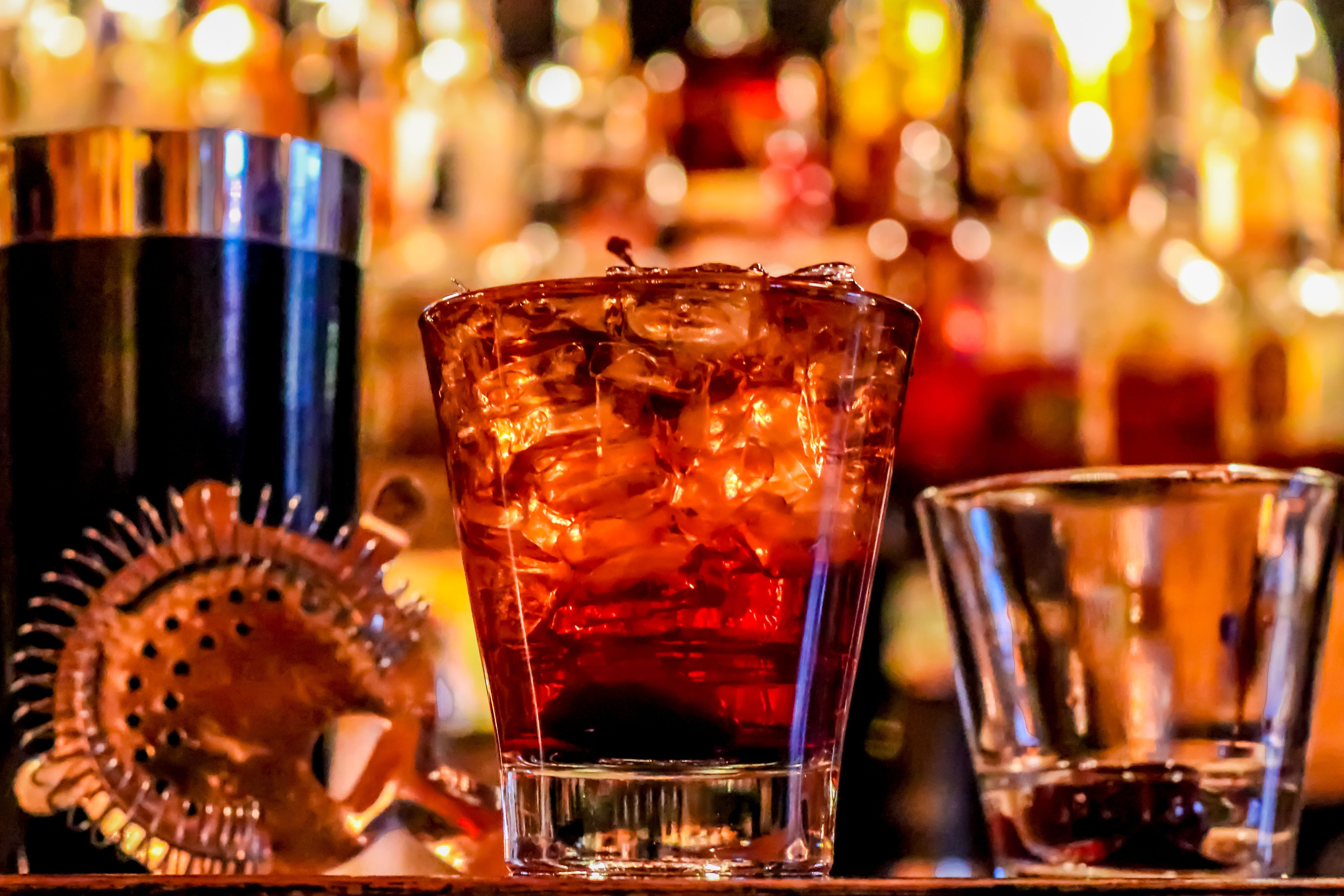 Photo of a bar with a glass strainer and shaker